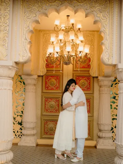A quiet embrace in a royal setting. This shot captures the luxury and intimacy of a destination pre-wedding shoot, with the grandeur of the palace architecture framing a deeply personal moment.
