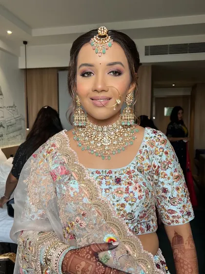 A full-face view, her makeup perfectly complementing the pastel colors of her outfit and jewelry.