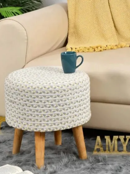 A light and airy white and beige woven jute stool. This neutral piece complements a wide range of decor styles, from coastal to bohemian.