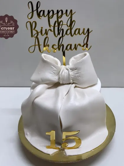 A chic and simple gift box cake with a large, handcrafted white bow. This half-kg chocolate truffle cake is perfect for a sophisticated 15th birthday celebration.