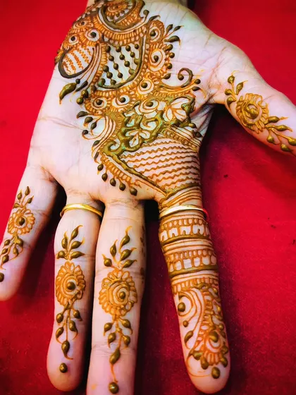 A delicate and pretty party design with a central peacock motif and fine, dangling chains on the fingers.