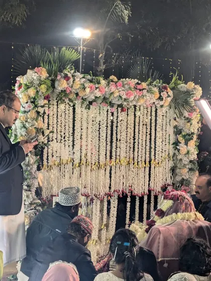 A candid moment from a Nikah ceremony, with the family gathered around the decorated partition. The decor provides a beautiful backdrop for these precious memories.