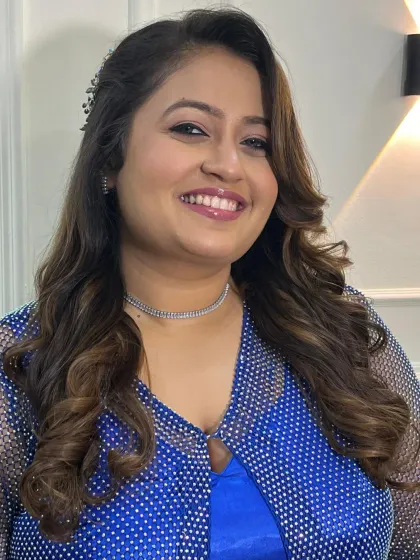 A happy and smiling portrait of the client, her makeup looking fresh and glamorous.