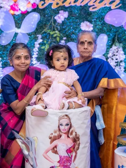 A precious multi-generational photo of a baby girl with her grandmothers at her first birthday party. Capturing the love between generations is a key part of our family event photography.