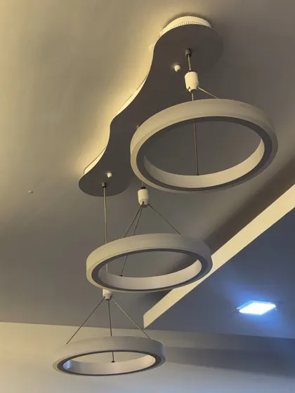 Installation of a contemporary three-ring LED pendant light. This type of modern chandelier is perfect for living rooms or dining areas, and I ensure it's hung securely and wired correctly for optimal performance.