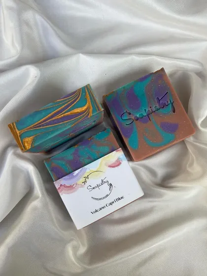 The Volcano Capri Blue soap, a vibrant mix of teal, purple, and gold. The colors and design are inspired by dramatic landscapes.