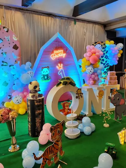A barnyard animal themed first birthday, with a red barn backdrop and various farm animal cutouts.