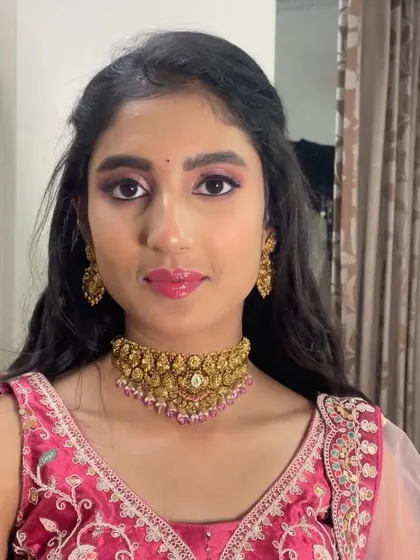 A closer look at Neha's party makeup. The antique gold choker pairs beautifully with the pink tones in her lehenga and makeup.