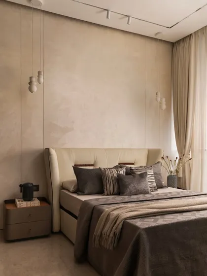I believe a neutral palette is the perfect canvas for tranquility. In this master bedroom, I layered various shades of beige and grey with different textures, from the plush headboard to the soft linens, creating a space that feels both sophisticated and incredibly restful.