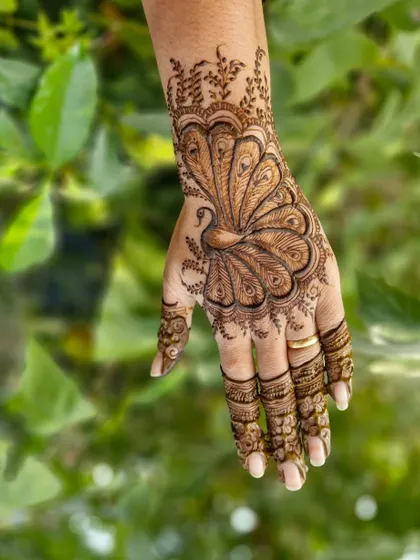 A close-up of the peacock motif on the back of the hand. I love creating these graceful birds as they are a timeless symbol in Indian mehendi art.