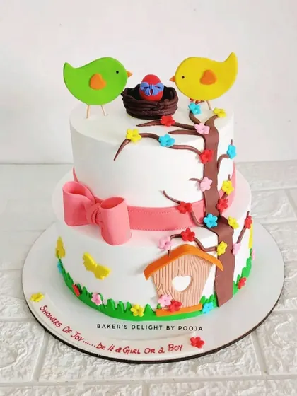 A unique baby shower cake for a client who loves birds. This two-tier design features a nest with an egg and two lovebirds, avoiding the typical pink and blue for a more personalized theme.