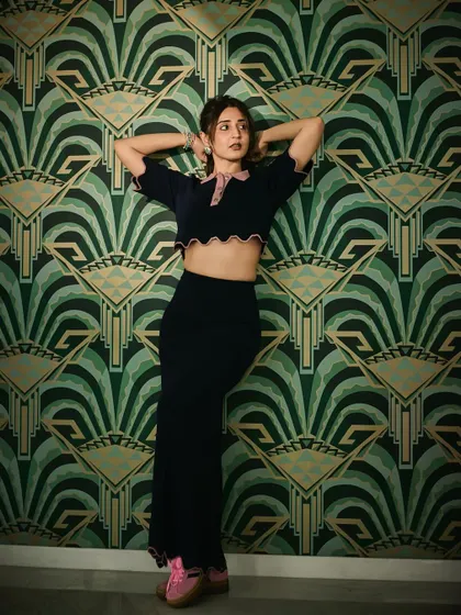 The art-deco wallpaper provides a stunning backdrop for this chic navy and pink set. It's all about how the fashion interacts with the environment.