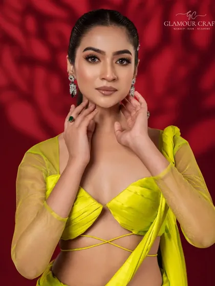 A striking beauty shot with a bold, modern aesthetic. The lime yellow blouse and deep red background create a stunning color contrast, while the makeup remains clean and sharp.