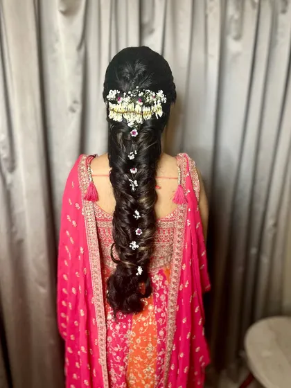 An intricate fishtail braid decorated with small flowers. This hairstyle is both glamorous and bohemian, perfect for a Mehendi.