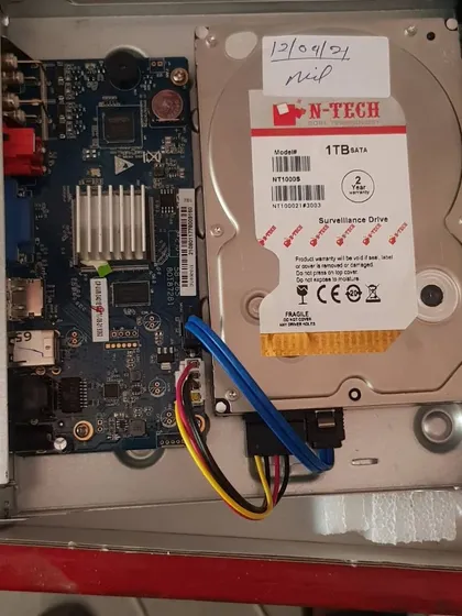 The inside of a DVR showing the N-Tech 1TB surveillance hard drive and the main circuit board.