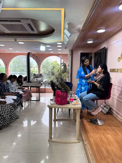 My studio is designed for learning. Here, I'm demonstrating an eye makeup look on a model, while students observe and take notes before their own hands-on practice session.