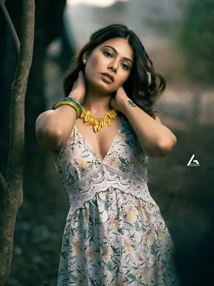 This is a classic outdoor portrait, where the shallow depth of field blurs the background and brings all the attention to the subject. The model's pose and direct gaze create a strong connection with the viewer, making it an impactful shot for a portfolio.