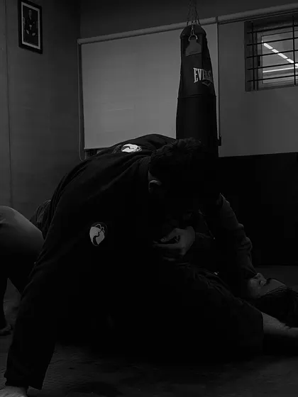 In the quiet moments of a roll, you are playing, learning, and working all at once. This black and white shot captures the intense focus of a Gi training session, where every grip and movement matters.