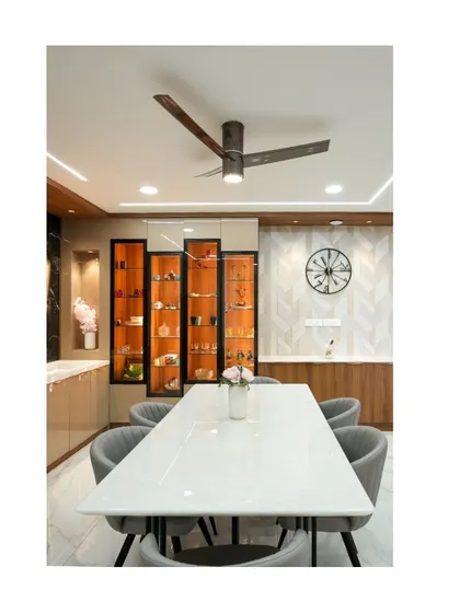 This meticulously crafted villa dining room is a symphony of style and function. The long marble table, grey upholstered chairs, and striking orange-lit display cabinets create an atmosphere of refined hospitality.
