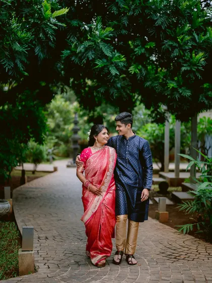 Apeksha and Rutwij take a romantic stroll through a garden path during their engagement shoot.