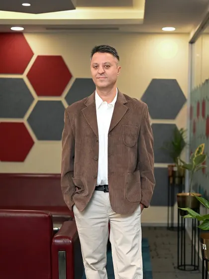 A standing portrait in a modern office hallway. Using the environment helps tell a story about the company culture, in this case, one that is creative and dynamic.