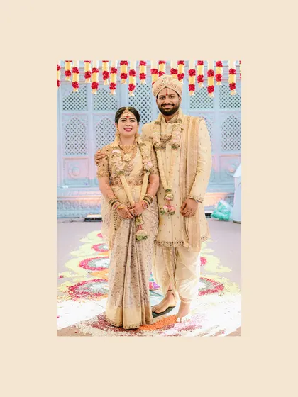 A full-length shot of the bride and groom, Diana and Pavan, in their perfectly matched cream and gold wedding attire.