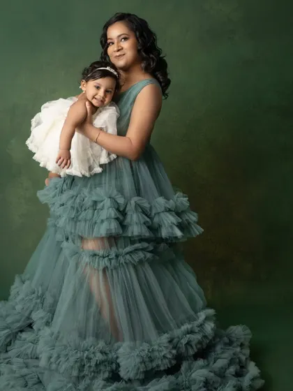 A graceful portrait of a mother and her daughter. The mother's flowing green gown and her daughter's sweet smile make for an enchanting image.