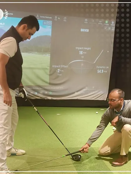 A hands-on moment during a Trackman session. I'm adjusting the client's setup based on the swing data we are seeing on the simulator screen.