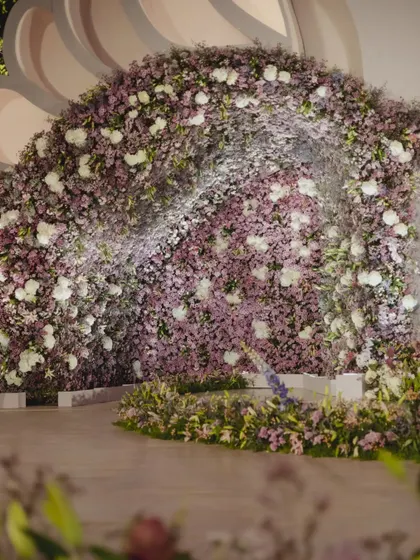 A close-up of the floral arrangements at the castle reception, with a massive wall of purple and white flowers creating a dramatic and romantic effect.
