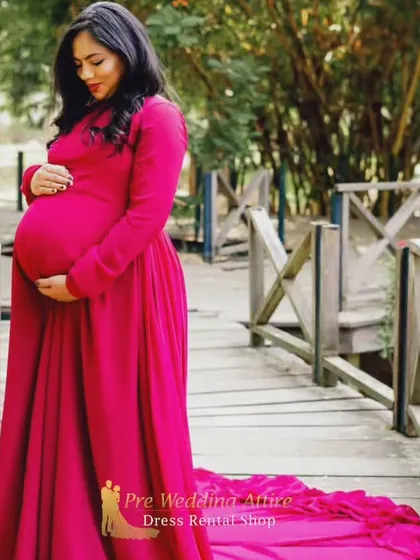 A close-up view of the magenta flying tail gown, showing its rich color and the way the fabric drapes. This rental dress is perfect for capturing both full-body and detailed shots during your pregnancy photoshoot.