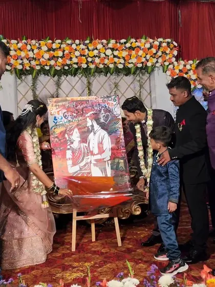 Here, the couple is adding their own touch to the canvas. This interactive element makes the artwork even more personal, turning it into a collaborative keepsake from their wedding reception.