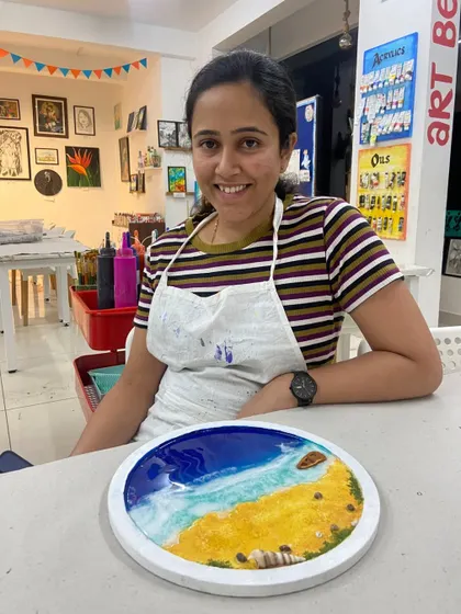 A smiling participant with her completed resin beach art. The joy of creating something beautiful with your own hands is what my workshops are all about.