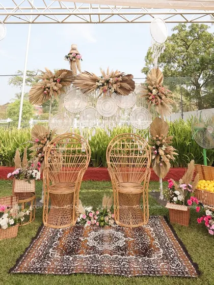 We designed this special seating for the couple, featuring rustic rattan peacock chairs on a patterned rug. The backdrop of woven plates, dreamcatchers, and dried florals completes the bohemian aesthetic for a Haldi or Mehndi ceremony.
