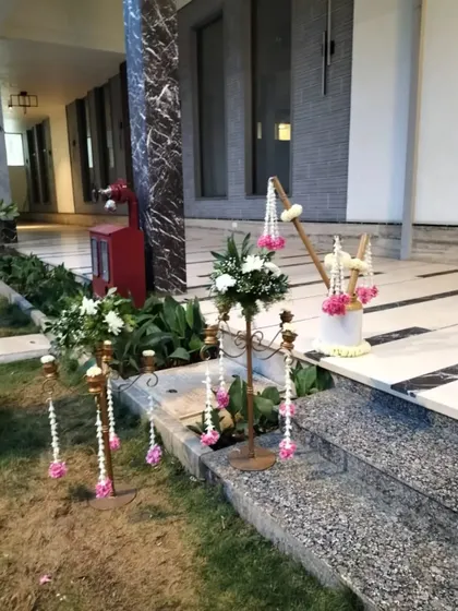 Delicate floral arrangements on candelabras, with hanging strings of jasmine and pink flowers, adding a touch of grace and tradition to the decor.