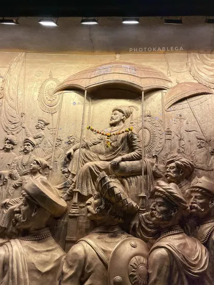An intricately carved bas-relief sculpture depicting Chhatrapati Shivaji Maharaj in his court, showcasing incredible craftsmanship.