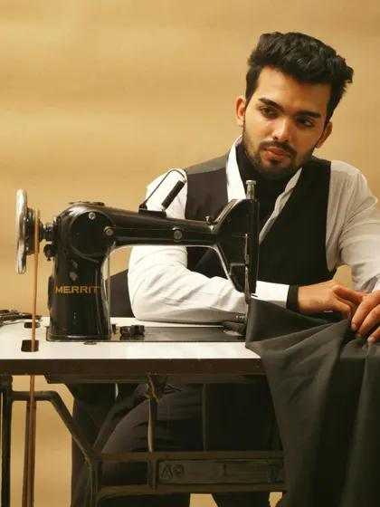 This conceptual portrait uses a vintage sewing machine as a prop to tell a story about craftsmanship and style. It's a creative shot designed to add depth and personality to a model's book, moving beyond simple headshots.