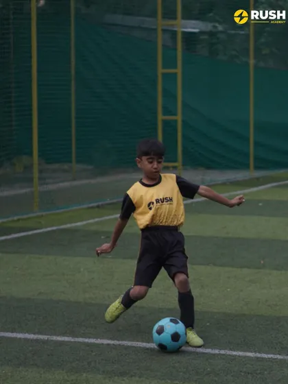 A young player focuses on controlling the ball. Mastering the first touch is a critical skill we emphasize in our training.