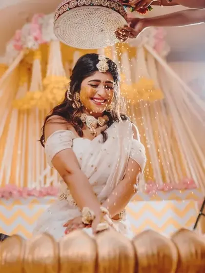 Capturing the pure joy of the Haldi ceremony. The bride is showered with flowers and turmeric, and my decor with its bright yellow drapes and floral accents creates a perfectly festive atmosphere.