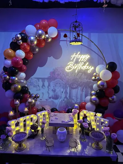 Another angle of the 'Smokey Lounge' decor, showing the balloon arch and detailed table setup with candles and props.