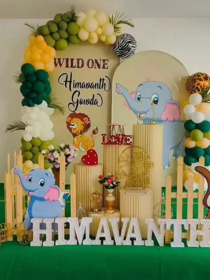 A "Wild One" jungle theme is one of our specialties. This setup for Himavanth's first birthday features cute animal cutouts, a lush green color palette, and a custom backdrop for a fun-filled celebration.