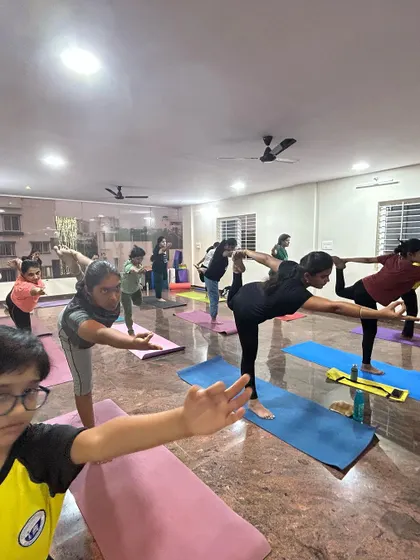 Students holding Warrior III pose, a test of balance and concentration. Each class is an opportunity to challenge ourselves and grow.