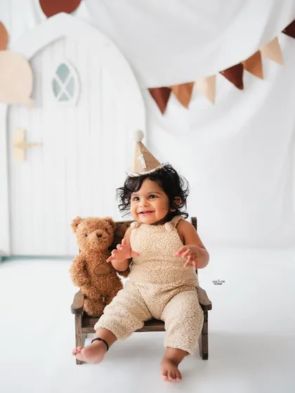 A happy birthday boy in his teddy bear themed first birthday shoot.