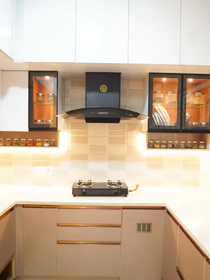 A straight-on view of the cooking area, highlighting the modern chimney and the clean lines of the cabinetry. The neutral color palette creates a calm and timeless appeal.
