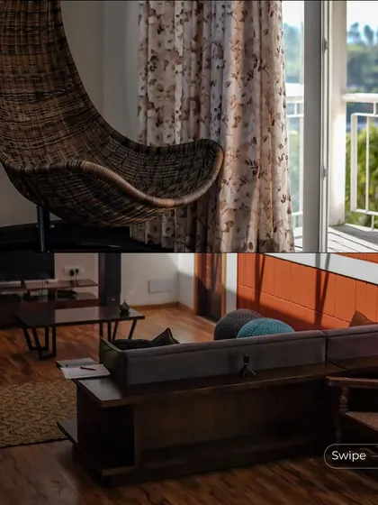 The interior features a hanging wicker swing chair, providing a perfect reading spot by the window. The living area is furnished with a comfortable sofa and wooden coffee table, creating a relaxed, modern farmhouse feel.