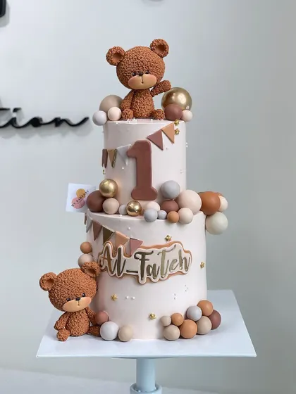 A cuddly and cute two-tiered bear-tastic first birthday cake.