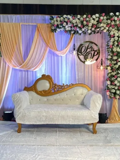 A closer look at the engagement stage, highlighting the floral arch and the custom 'OP' monogram. These personalized details make your event unique.
