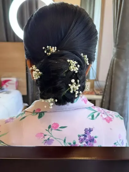 A clean, modern updo with delicate sprigs of baby's breath scattered throughout for a subtle, elegant touch.