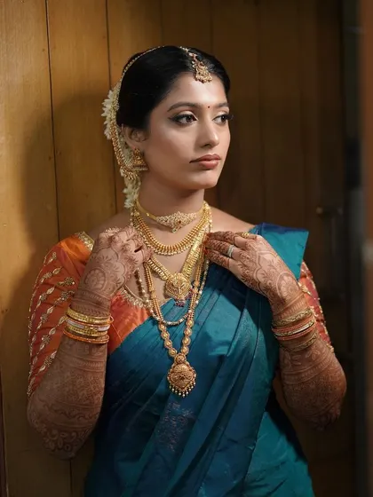 This bride's look is all about traditional elegance. The makeup enhances her features, while the rich silk saree and gold jewelry complete the look.
