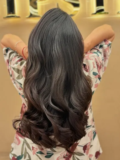 The back of a client's hair after a fresh haircut, styled with soft waves to show off the new layers and healthy ends.