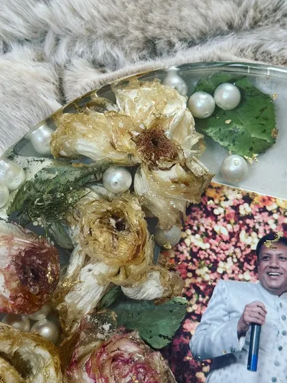 A close-up of a 25th-anniversary keepsake. The preserved flowers and pearls surround a joyful photo, celebrating a lifetime of love. It's an honor to preserve memories from all stages of a relationship.